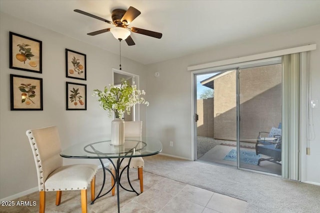 carpeted dining space with ceiling fan