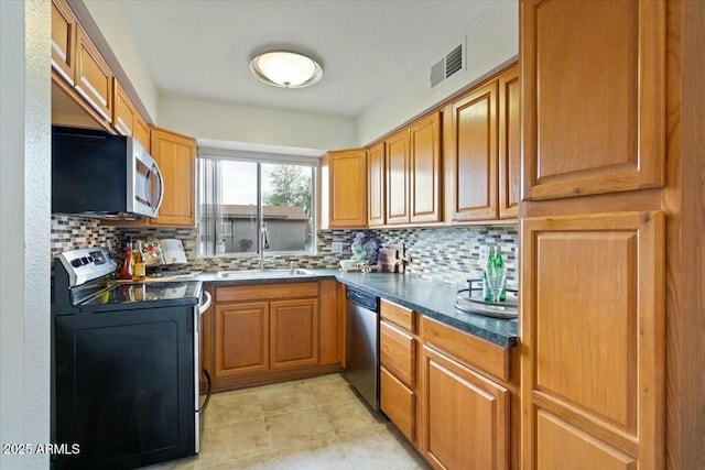 kitchen with tasteful backsplash, appliances with stainless steel finishes, and sink