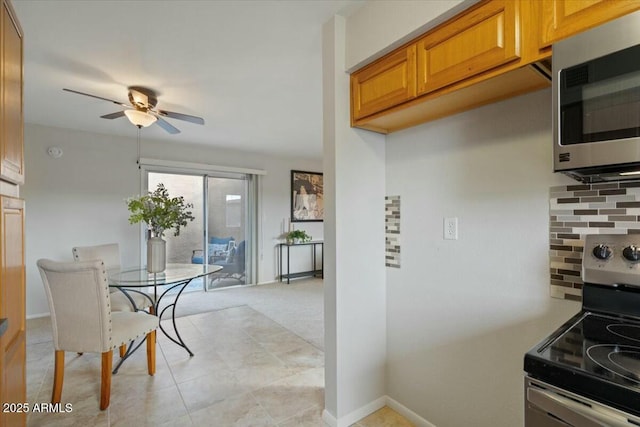 kitchen featuring stainless steel appliances, ceiling fan, and decorative backsplash