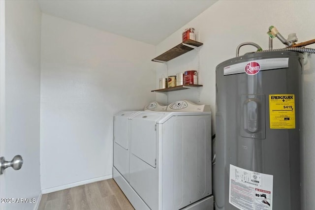 washroom featuring washer and clothes dryer, electric water heater, and light wood-type flooring