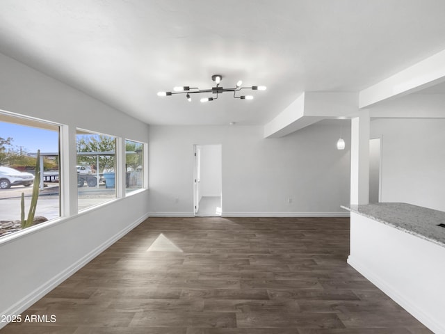 unfurnished living room featuring dark wood-type flooring and a chandelier