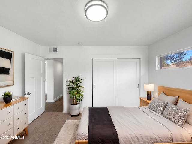 bedroom with a closet and dark colored carpet