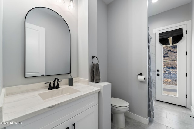 bathroom featuring toilet, vanity, and tile patterned floors