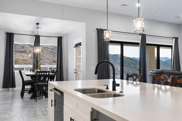 kitchen with a mountain view, pendant lighting, white cabinets, and sink