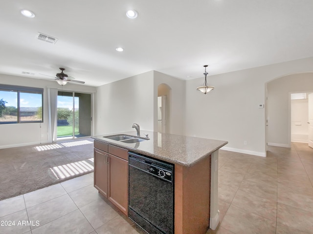 kitchen with light stone countertops, sink, decorative light fixtures, dishwasher, and an island with sink