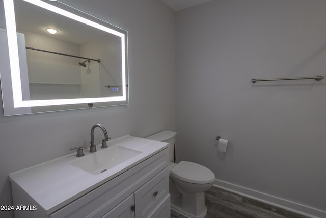 bathroom featuring oversized vanity, hardwood / wood-style flooring, and toilet