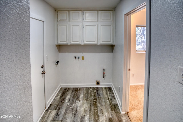 laundry area with gas dryer hookup, cabinets, and carpet floors