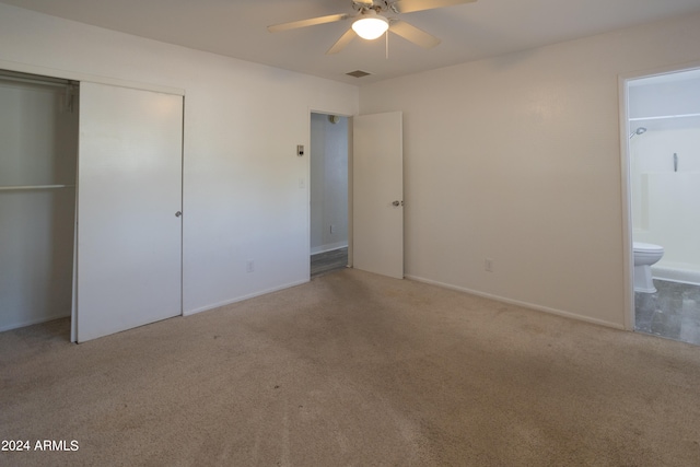 unfurnished bedroom with carpet flooring, a closet, connected bathroom, and ceiling fan