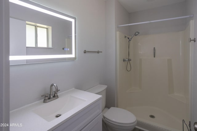 bathroom featuring walk in shower, vanity, and toilet