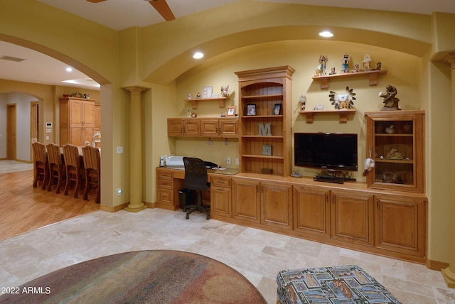 home office featuring built in desk and ceiling fan