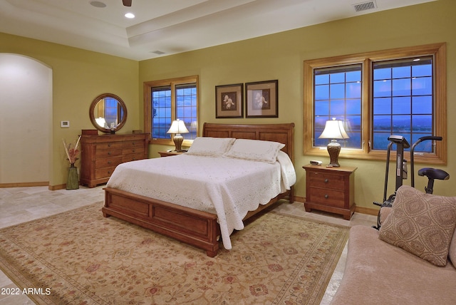 bedroom featuring ceiling fan and a tray ceiling