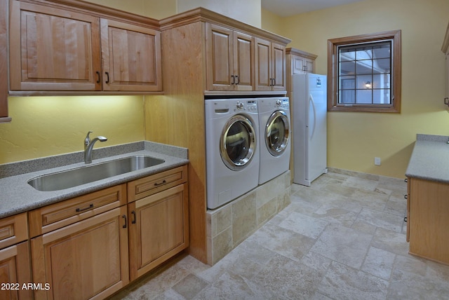 laundry room with washer and clothes dryer, cabinets, and sink