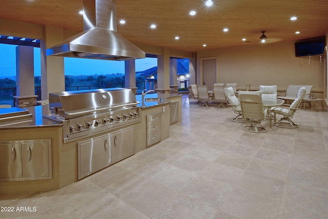 kitchen featuring light brown cabinets, wooden ceiling, wall chimney range hood, sink, and dark stone countertops