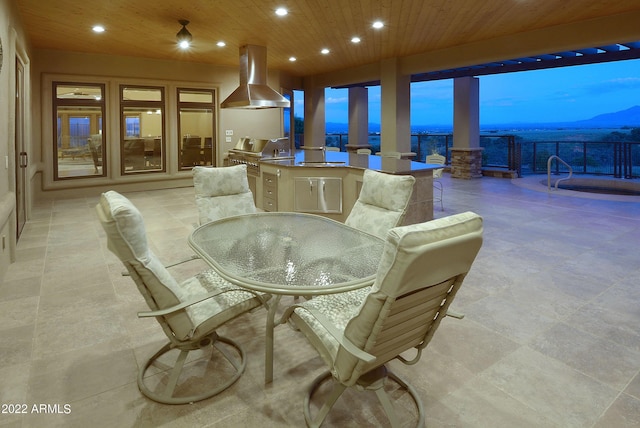 dining area with a water and mountain view and wood ceiling