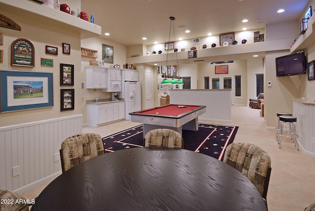 recreation room with a towering ceiling and billiards