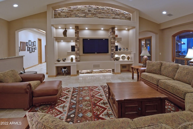 living room featuring high vaulted ceiling and built in features