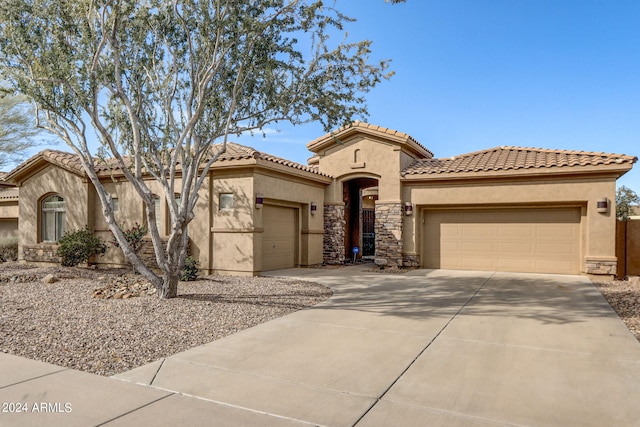 3660 S Golden Eye Ln, Gold Canyon, AZ 85118 - mediterranean / spanish house with concrete driveway, stucco siding, stone siding, a tiled roof, and a garage