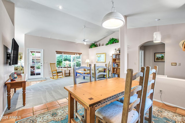 tiled dining space featuring lofted ceiling and ceiling fan