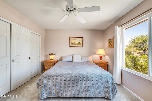 carpeted bedroom with multiple windows, ceiling fan, and a closet