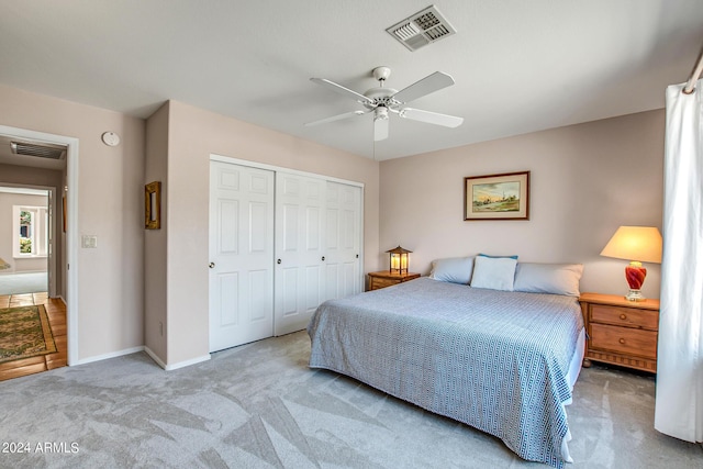 bedroom with light carpet, a closet, and ceiling fan