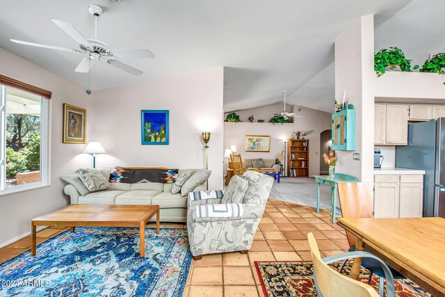 tiled living room featuring ceiling fan and vaulted ceiling