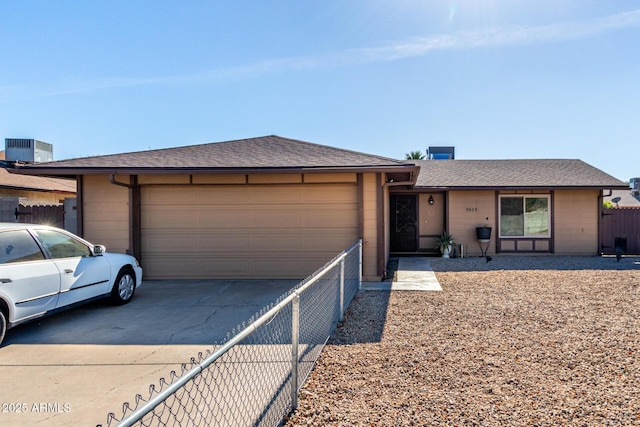 ranch-style home with a garage and central AC