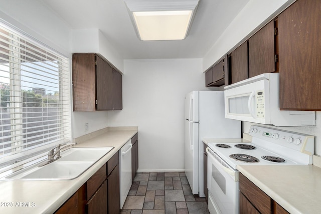 kitchen with dark brown cabinets, white appliances, and sink