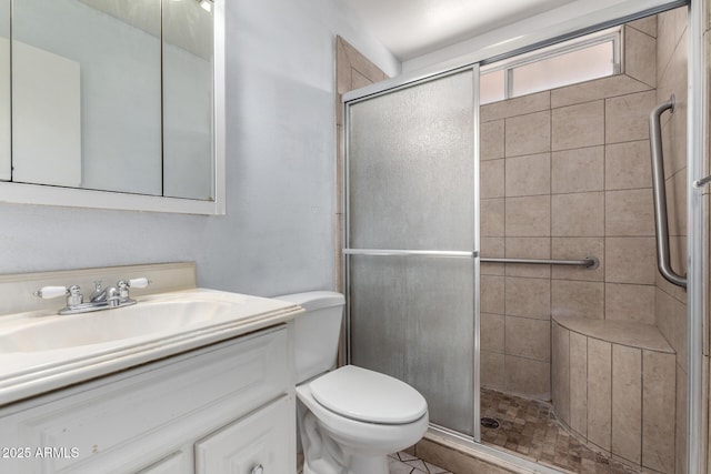 bathroom with vanity, toilet, and a shower with door