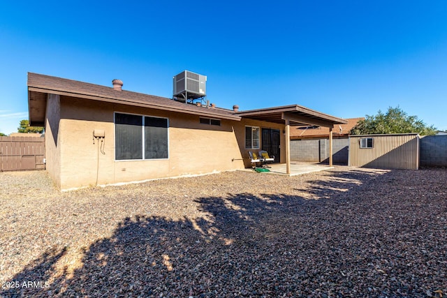 back of property featuring a storage unit, central air condition unit, and a patio