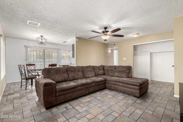 living room featuring ceiling fan with notable chandelier