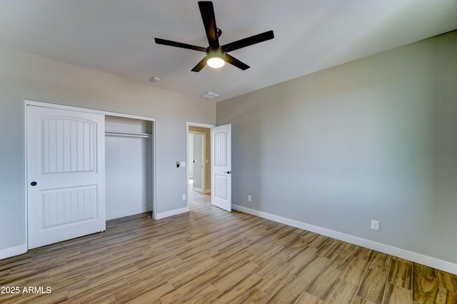 22009 W Montgomery Rd, Wittmann, AZ 85361 - unfurnished bedroom with light wood-style flooring, a closet, baseboards, and a ceiling fan