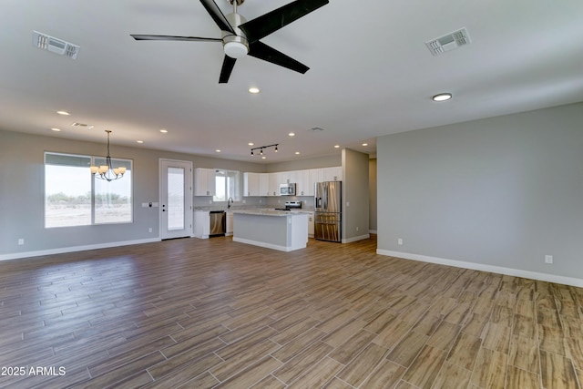 22009 W Montgomery Rd, Wittmann, AZ 85361 - unfurnished living room featuring a chandelier, wood finished floors, baseboards, ceiling fan, and recessed lighting