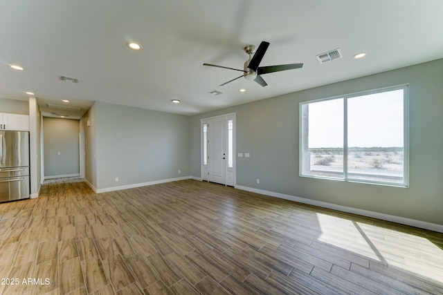 22009 W Montgomery Rd, Wittmann, AZ 85361 - unfurnished living room featuring a ceiling fan, baseboards, light wood-type flooring, and recessed lighting