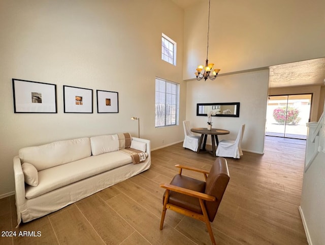 living room featuring a chandelier, hardwood / wood-style floors, and a high ceiling