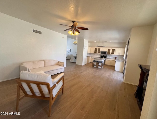 living room featuring ceiling fan and hardwood / wood-style flooring