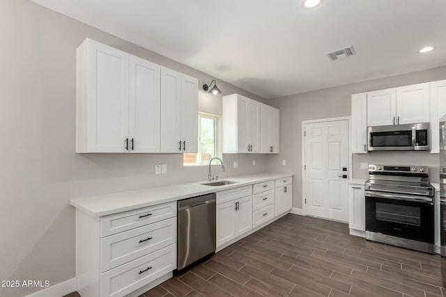 683 W Raymond St, Coolidge, AZ 85128 - kitchen with stainless steel appliances, a sink, baseboards, recessed lighting, and white cabinetry