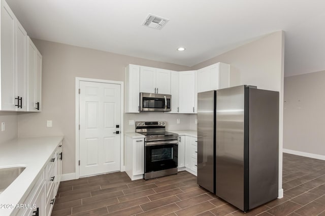 683 W Raymond St, Coolidge, AZ 85128 - kitchen with stainless steel appliances, wood finish floors, baseboards, recessed lighting, and white cabinetry