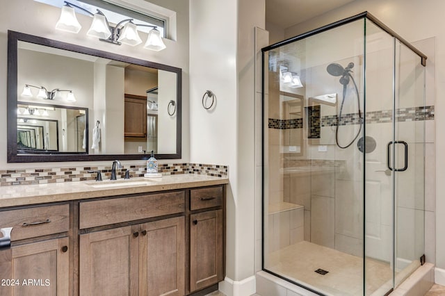 bathroom featuring backsplash, an enclosed shower, and vanity