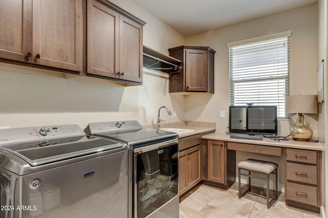 clothes washing area featuring cabinets, sink, light tile floors, and washer and dryer