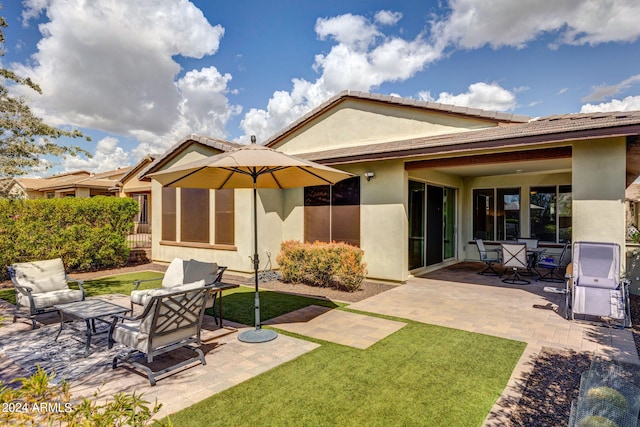 rear view of house featuring a patio area and a lawn