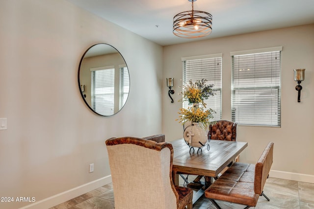 dining area with a notable chandelier and light tile floors