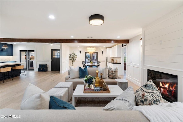 living room featuring beam ceiling and light hardwood / wood-style floors