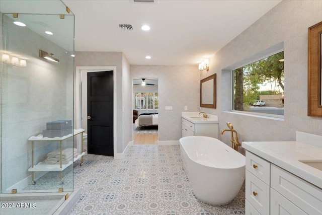 bathroom with a wealth of natural light, vanity, separate shower and tub, and ceiling fan