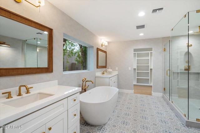 bathroom featuring a sink, a shower stall, a soaking tub, and visible vents