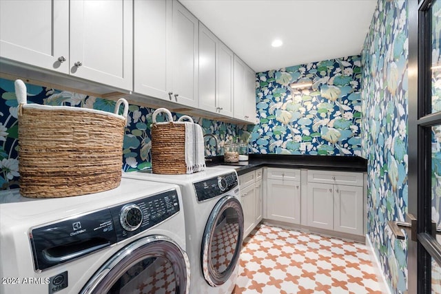 clothes washing area featuring recessed lighting, wallpapered walls, washer and dryer, cabinet space, and a sink