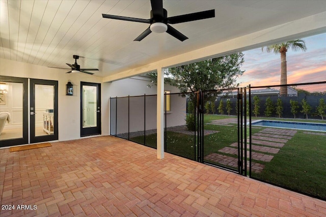 patio terrace at dusk featuring french doors and ceiling fan