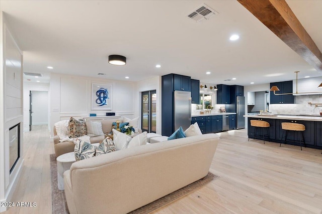 living room featuring visible vents, light wood-style floors, and recessed lighting