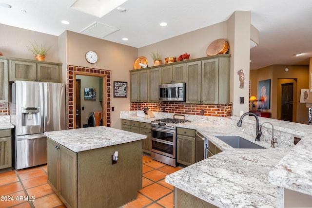 kitchen featuring sink, a center island, kitchen peninsula, decorative backsplash, and appliances with stainless steel finishes