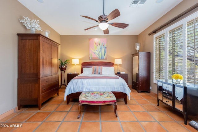 tiled bedroom featuring multiple windows and ceiling fan