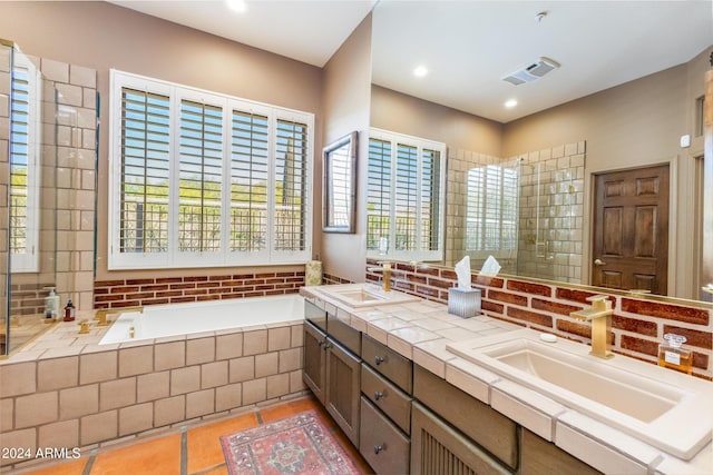 bathroom featuring tile patterned floors, tiled tub, and vanity